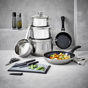 Kochtopf-Starter-Set 10-tlg. aus Edelstahl, bestehend aus mehreren Töpfen und Pfannen, mit Küchenutensilien wie Messer und Schneidebrett, in einer modernen Küchenumgebung von vorne fotografiert.