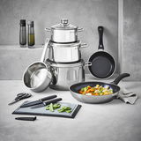 Kochtopf-Starter-Set 10-tlg. aus Edelstahl, bestehend aus mehreren Töpfen und Pfannen, mit Küchenutensilien wie Messer und Schneidebrett, in einer modernen Küchenumgebung von vorne fotografiert.