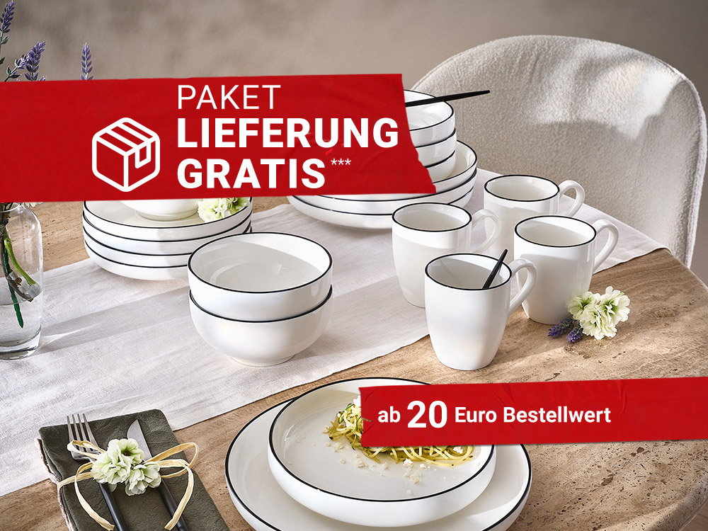 Weißes Geschirr mit schwarzem Rand auf gedecktem Esstisch, dekoriert mit Blumen und Besteck.