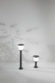 Zwei moderne Pollerleuchten der Serie Fabas Luce THIAGO in unterschiedlichen Höhen, frontal betrachtet, vor einem Hintergrund mit Schatten von Blättern.