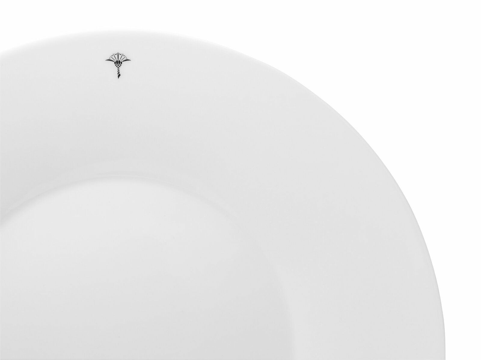 Nahaufnahme eines weißen Platztellers mit einem kleinen, dekorativen Symbol am Rand, von oben betrachtet.