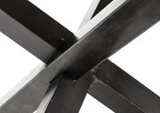 Nahaufnahme der Kreuzverbindung eines Metallgestells eines Esstisches, perspektivisch von unten aufgenommen.