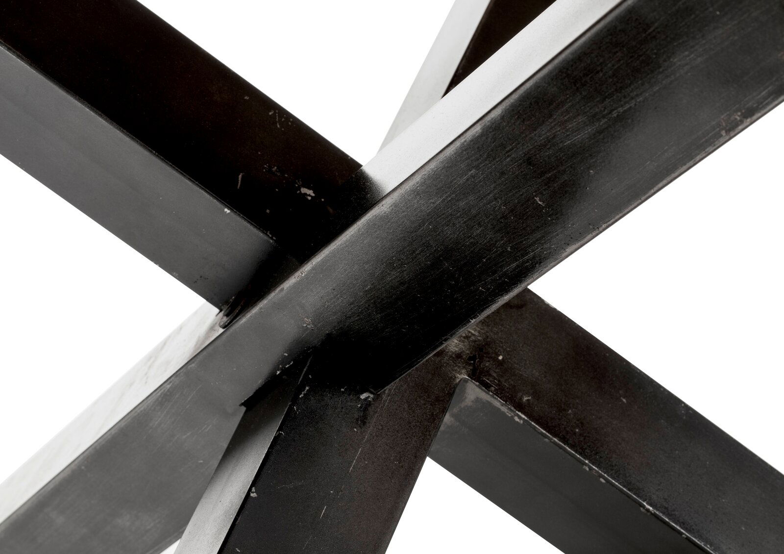 Nahaufnahme der Kreuzverbindung eines Metallgestells eines Esstisches, perspektivisch von unten aufgenommen.