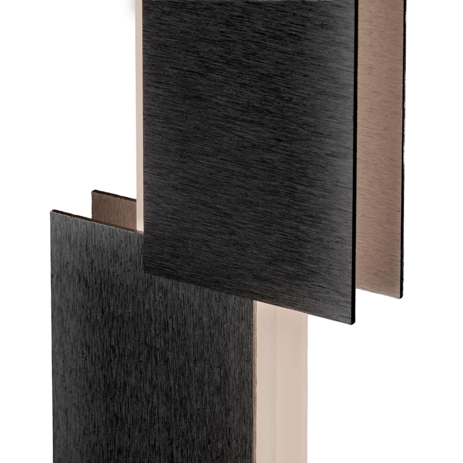 Detailansicht aus schräger Frontperspektive auf ein geometrisches Designobjekt mit überlappenden rechteckigen Elementen in Schwarz und Bronze