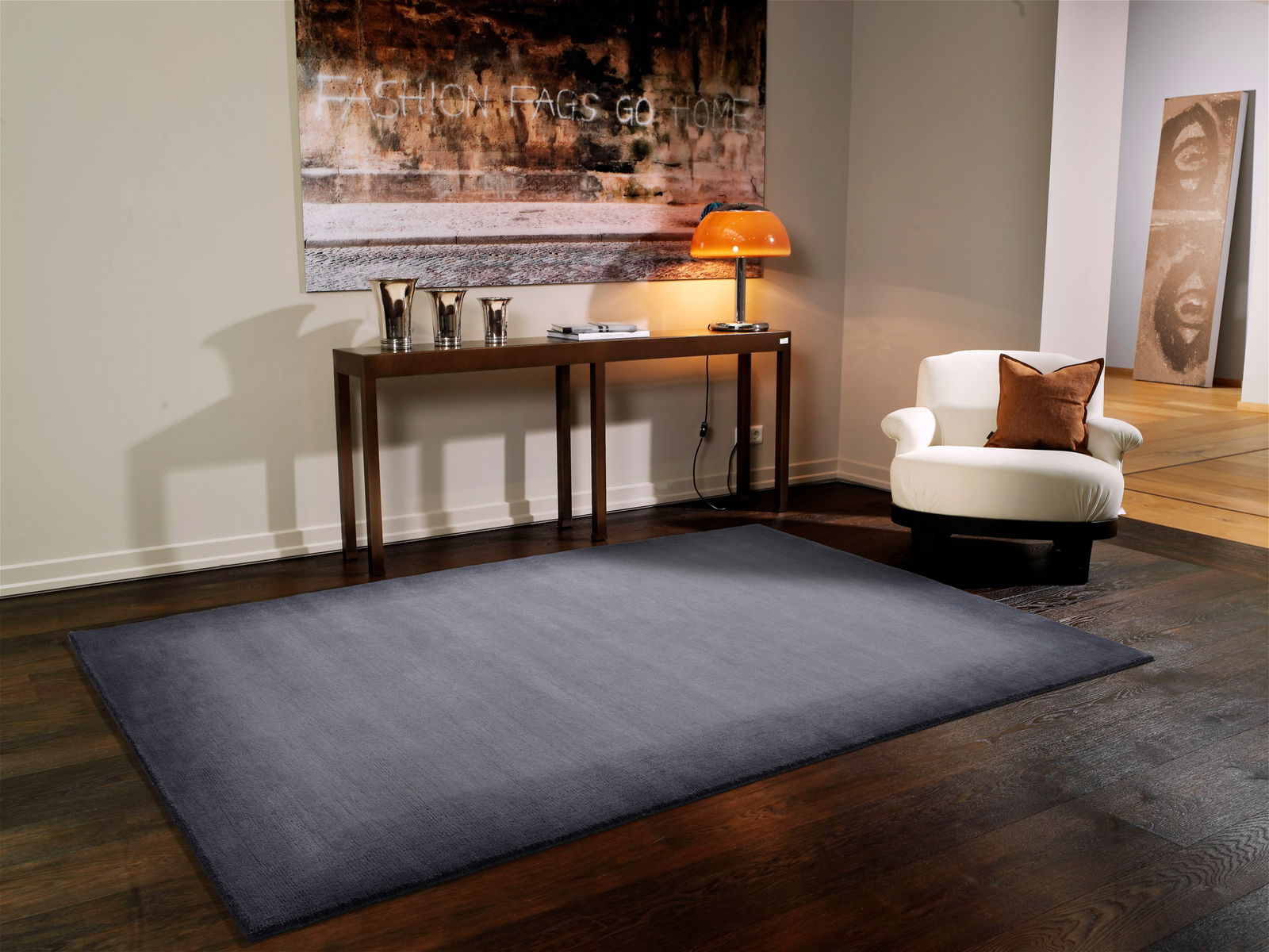 Moderner grauer Wollteppich in einem stilvoll eingerichteten Wohnzimmer, aus der Vogelperspektive betrachtet.