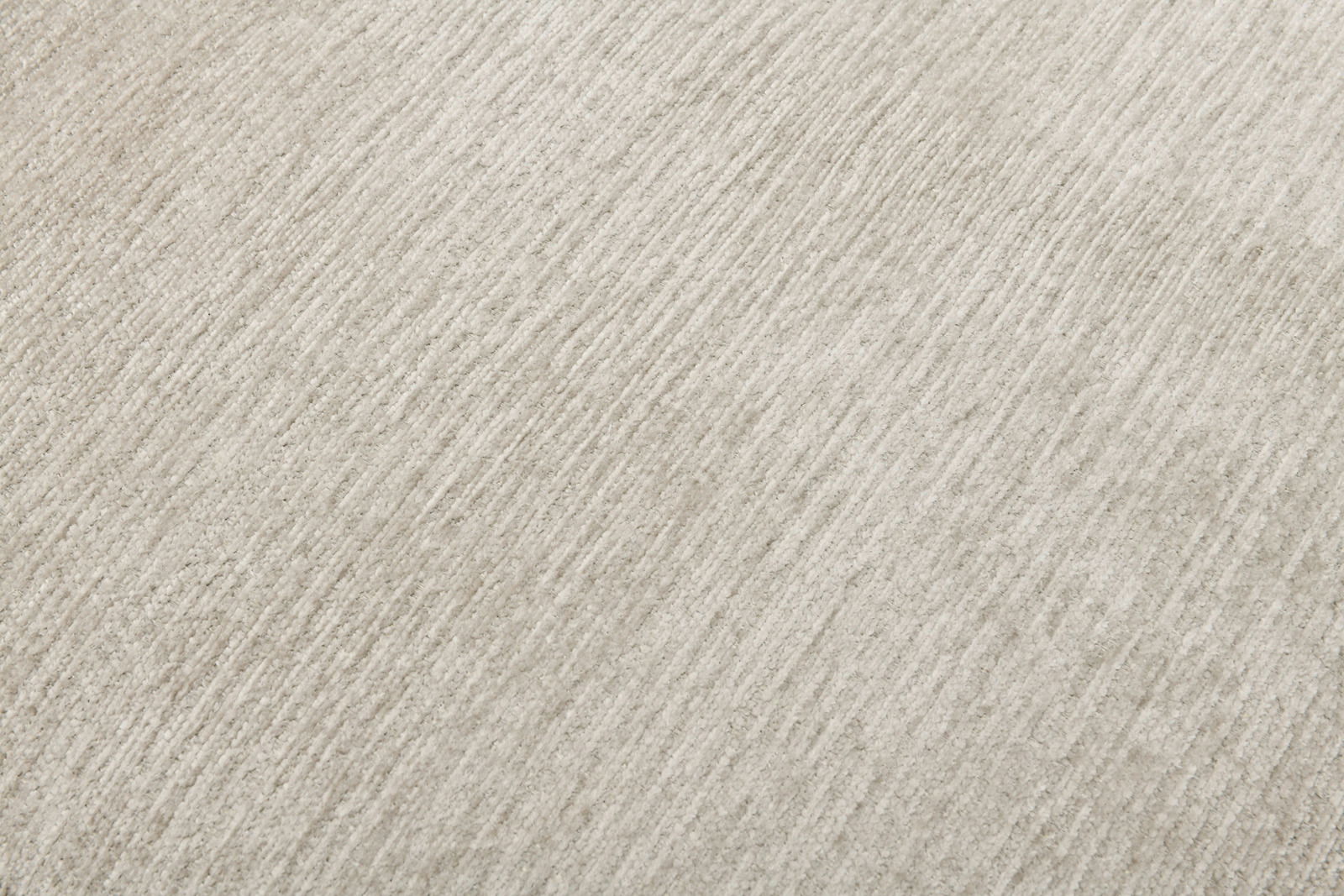 Nahaufnahme einer hellgrauen, strukturierten Stoffoberfläche in diagonaler Perspektive.