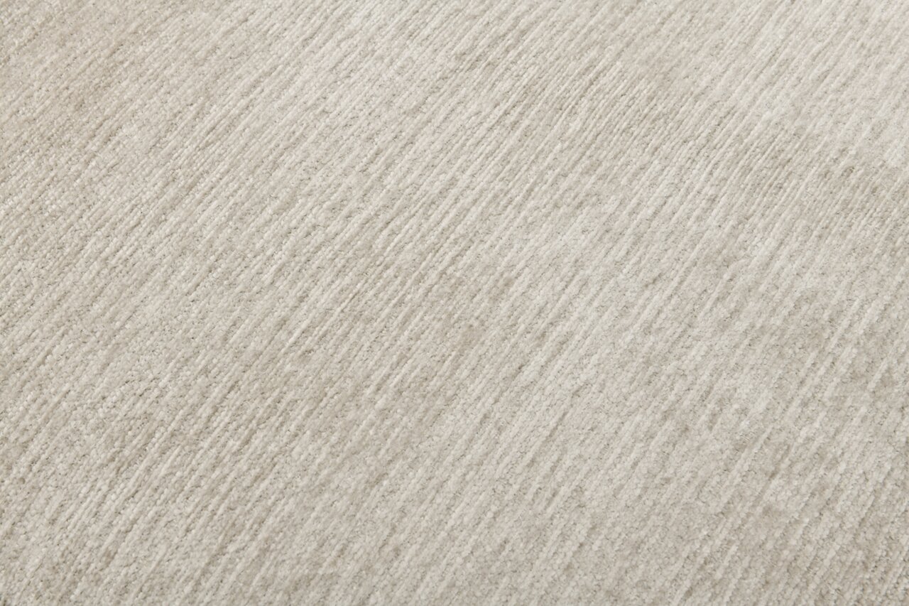 Nahaufnahme einer hellgrauen, strukturierten Stoffoberfläche in diagonaler Perspektive.