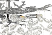 Nahaufnahme einer eleganten Deckenleuchte mit kristallklaren Anhängern und einem verzweigten, silbernen Metallrahmen.