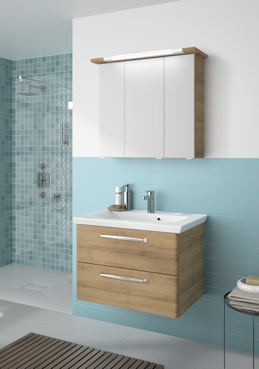 Moderner Badblock mit Holzoptik und weißem Waschbecken, frontal abgebildet vor blauen Fliesen.