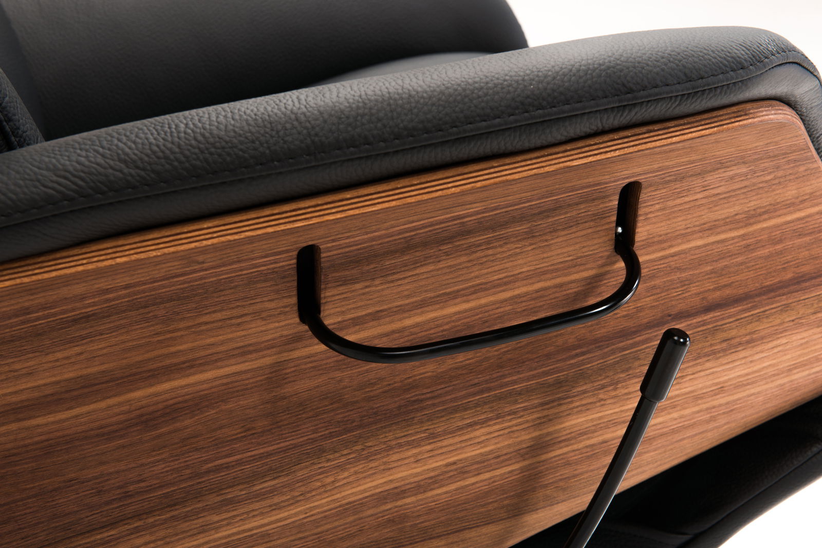 Detailansicht eines Relaxsessels mit schwarzem Lederbezug und Holzverkleidung, seitliche Perspektive.