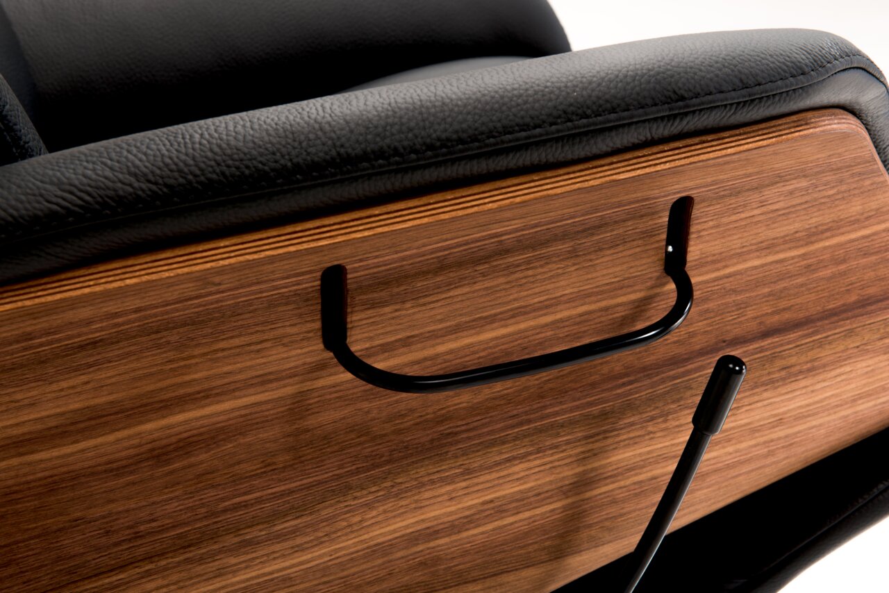 Detailansicht eines Relaxsessels mit schwarzem Lederbezug und Holzverkleidung, seitliche Perspektive.