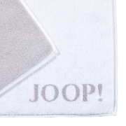 Weiße Badematte mit grauem Rand und dem Schriftzug 'JOOP!' in der Ecke, von oben fotografiert.