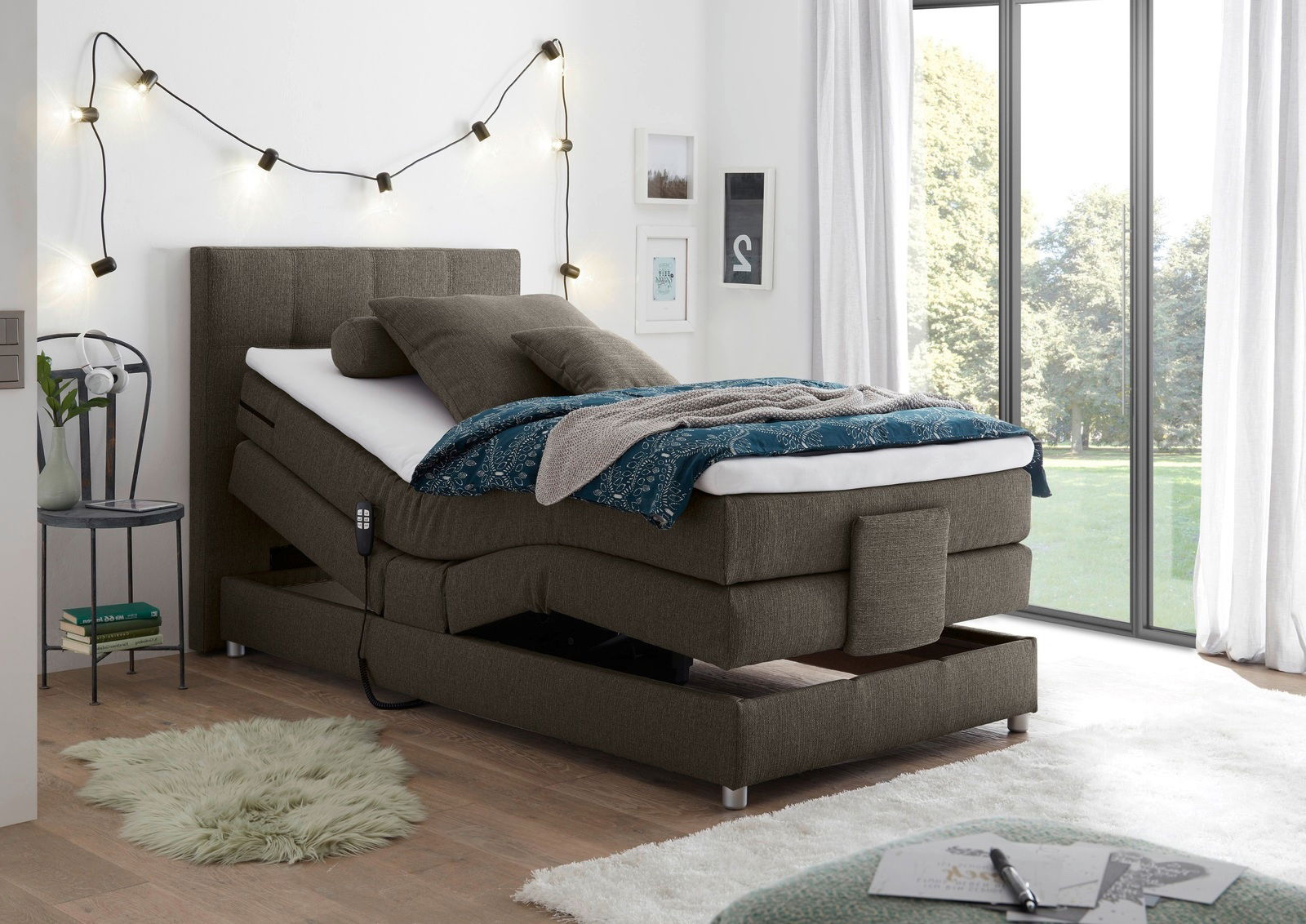 Boxspringbett in modernem Schlafzimmer, seitliche Perspektive, mit verstellbarem Kopfteil und gemütlicher Dekoration.