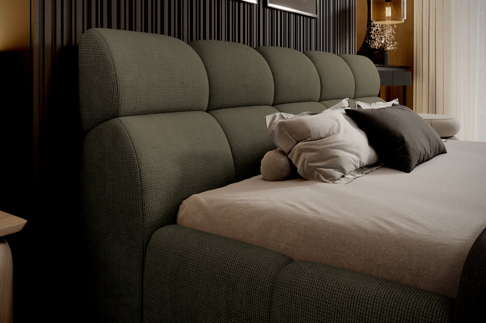 Zijaanzicht van een gestoffeerd bed met een groen hoofdeinde en verschillende kussens.