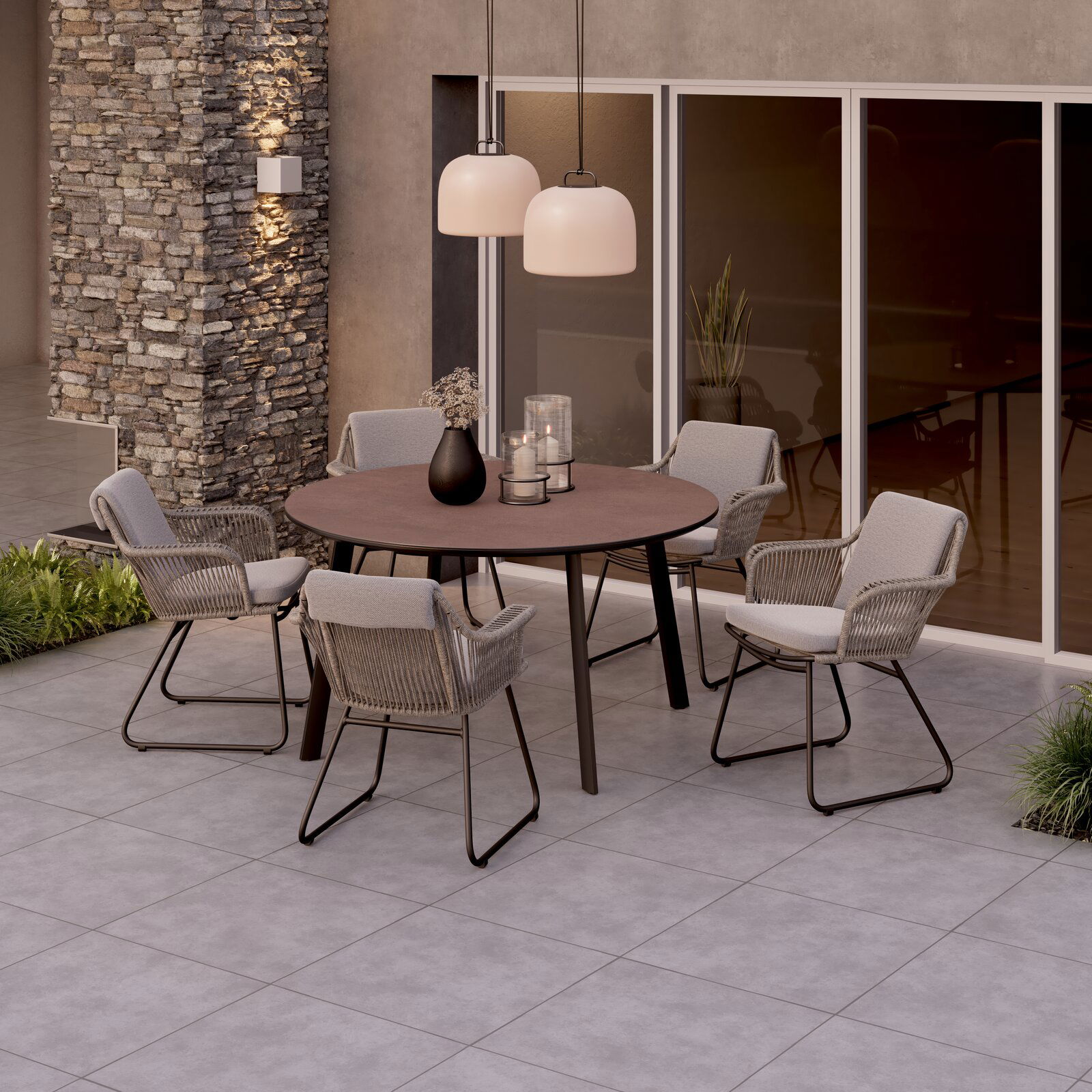 Moderner Armlehnstuhl auf einer Terrasse, um einen runden Tisch gruppiert, aus seitlicher Perspektive fotografiert.