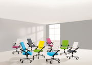 Eine Gruppe von bunten Jugenddrehstühlen in einem hellen Raum, aus einer leicht erhöhten Perspektive fotografiert.