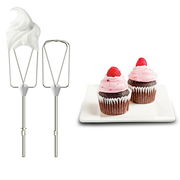 Zwei Rührbesen eines Handmixers, einer mit Sahne bedeckt, neben einem Teller mit zwei Cupcakes, aus der Seitenperspektive.