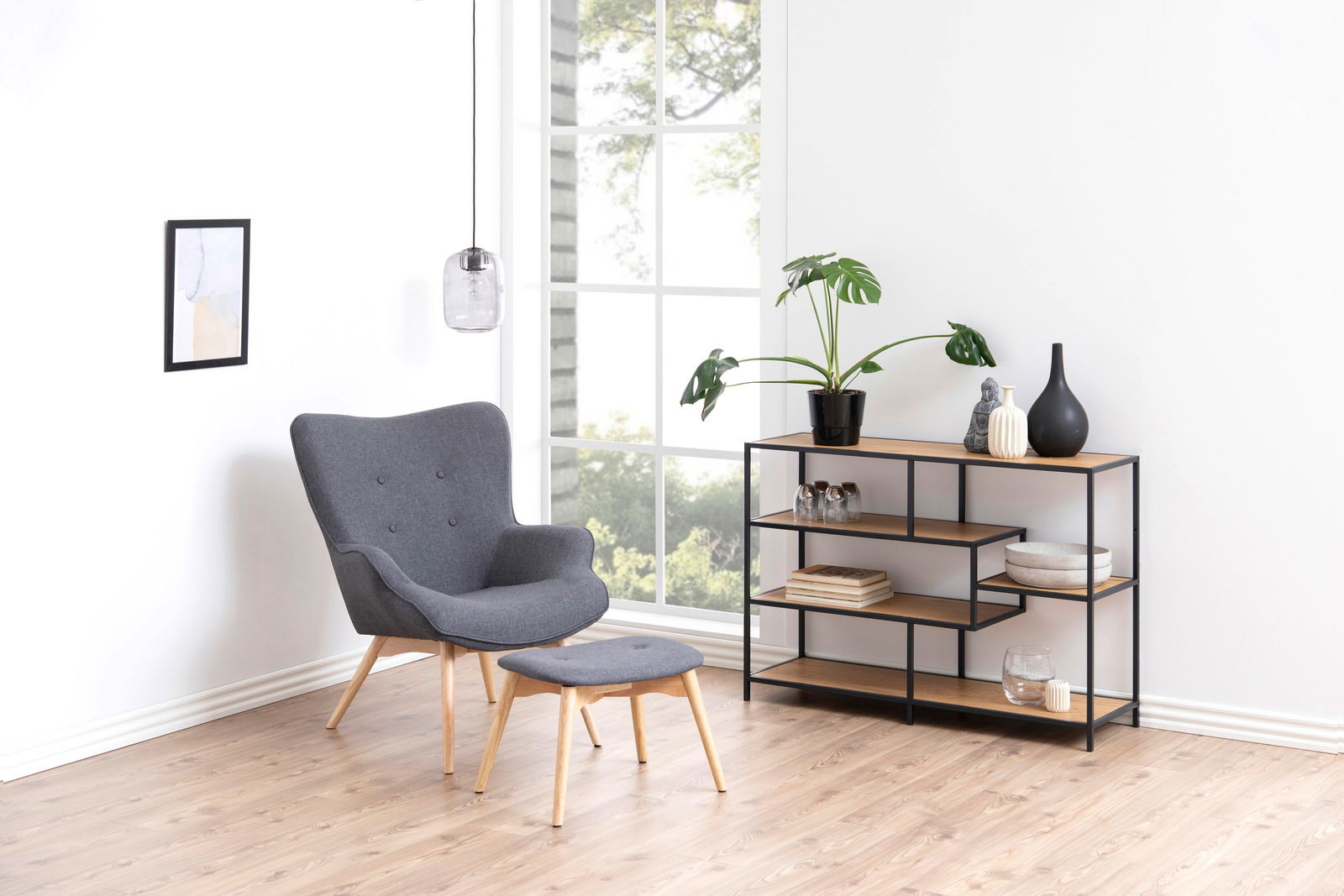 Modernes Bücherregal mit schwarzem Metallrahmen und Holzböden, seitliche Perspektive, dekoriert mit Pflanzen und Vasen, in einem hellen Raum mit Sessel und Hocker.