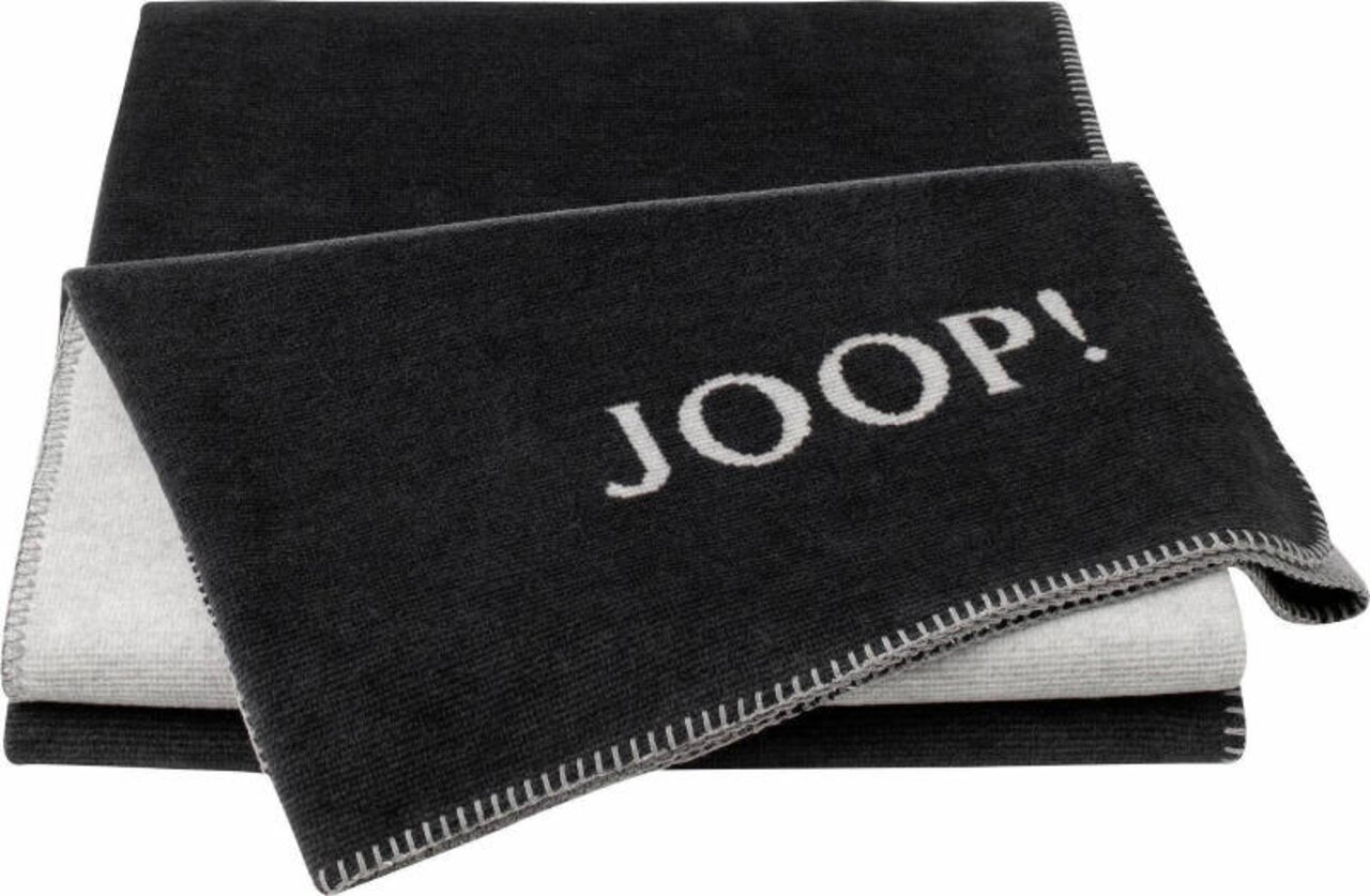 Dunkle Decke mit dem Schriftzug 'JOOP!' in weißer Schrift, gefaltet und von oben fotografiert.
