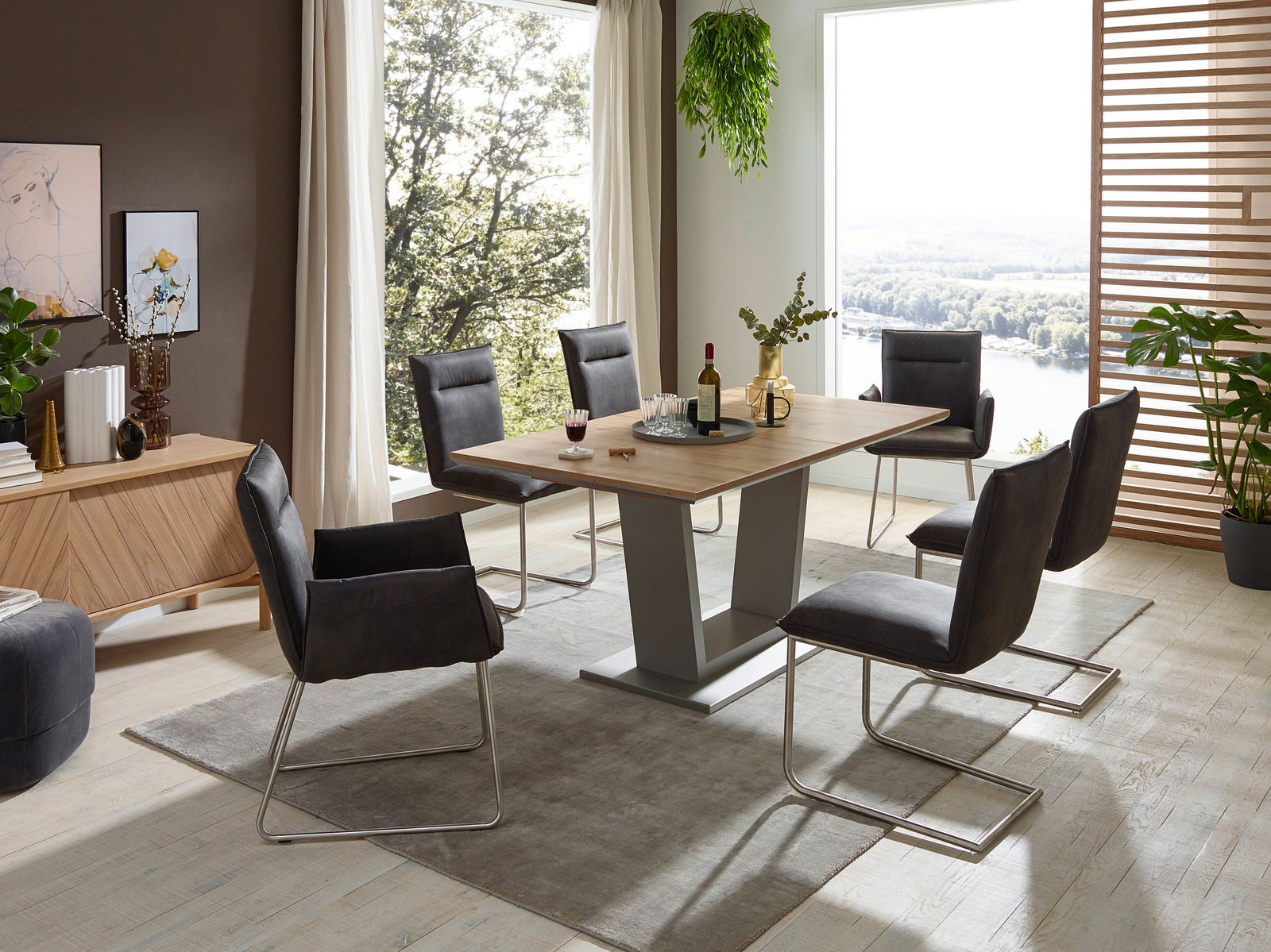 Valnatura Sessel SCALA Moderner Essbereich mit einem rechteckigen Holztisch und sechs Freischwinger-Stühlen in einem hellen Raum mit großen Fenstern und Pflanzen. Perspektive: seitliche Ansicht.