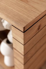 Nahaufnahme einer Ecke eines hölzernen Sideboards mit klaren Linien und natürlicher Holzmaserung, perspektivisch von oben aufgenommen.