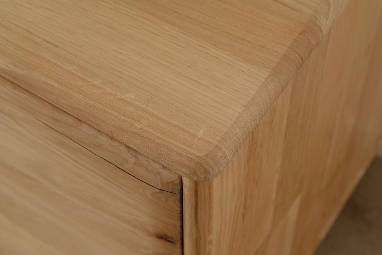 Nahaufnahme einer Holzmöbelecke mit glatter Oberfläche und abgerundeten Kanten.