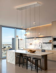 Moderne LED-Pendelleuchte in einer stilvollen Küche, von unten betrachtet, mit mehreren hängenden Leuchtkörpern über einer Kücheninsel.