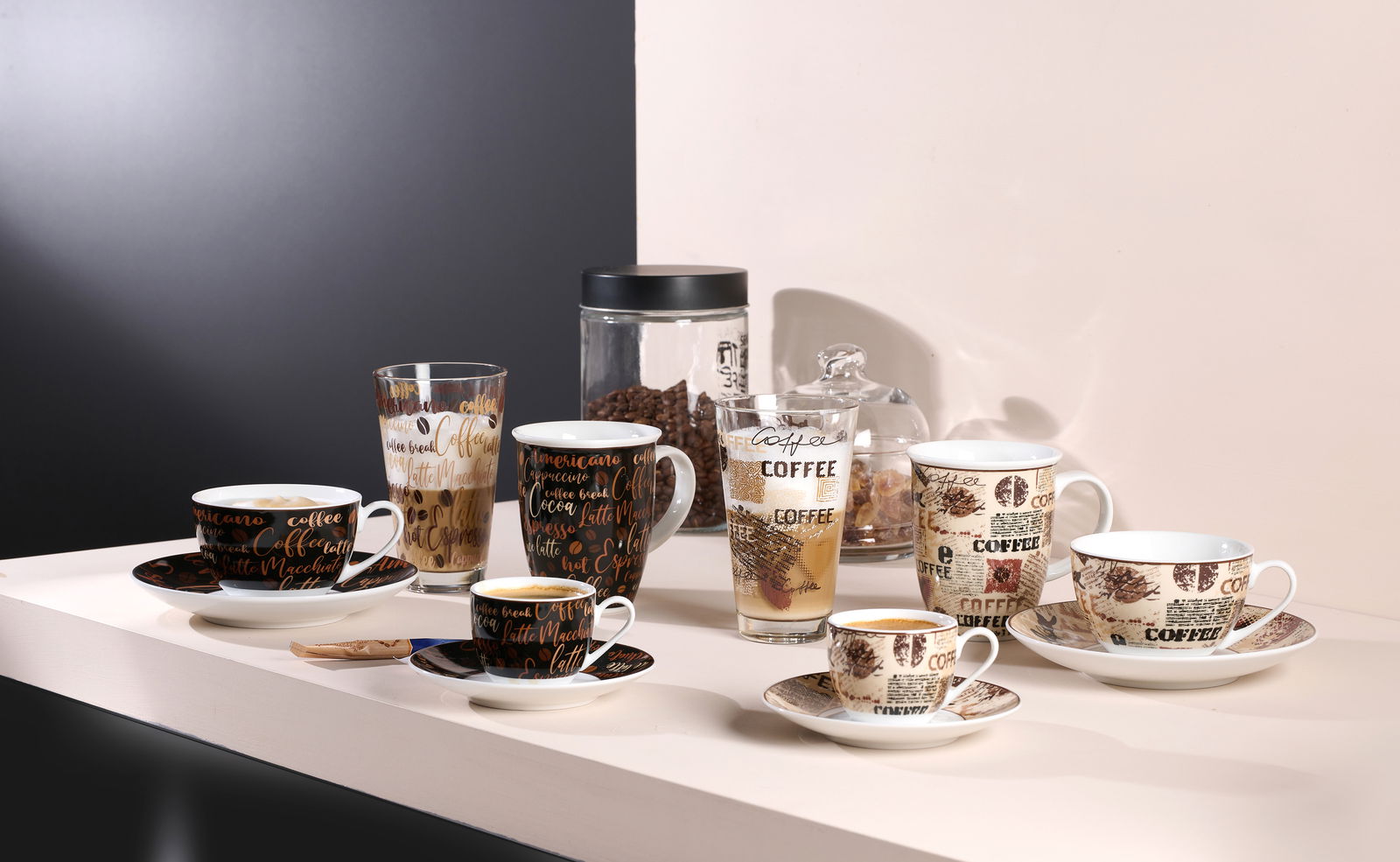 Verschiedene Kaffeetassen und Gläser mit dekorativen Schriftzügen und Mustern, seitliche Perspektive