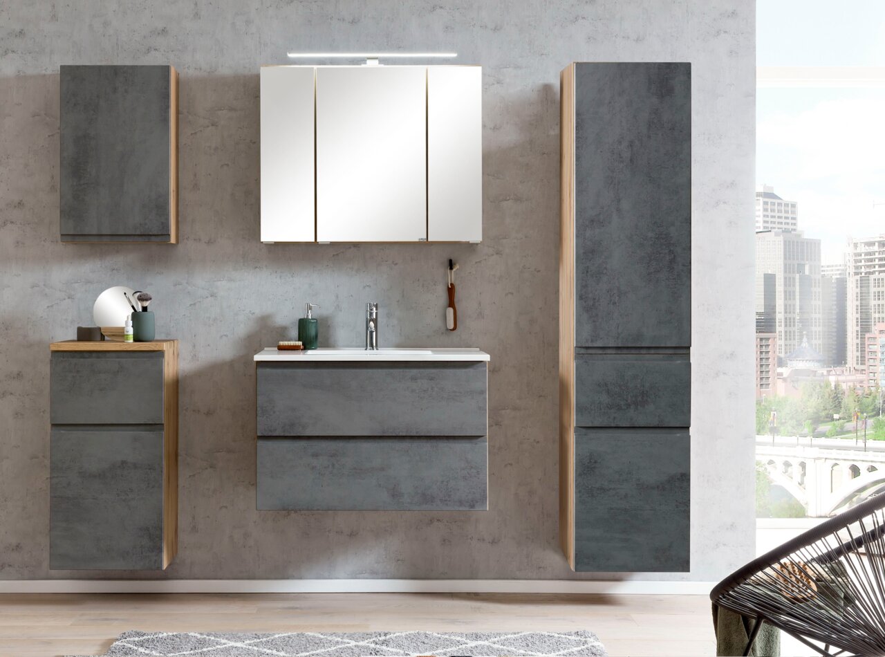 Moderne Badezimmermöbel in Betonoptik mit Hochschrank, Spiegelschrank und Waschbeckenunterschrank, frontal betrachtet.