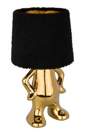 Goldene Tischleuchte mit schwarzem Lampenschirm in Form einer stilisierten Figur, frontal betrachtet.