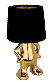Goldene Tischleuchte mit schwarzem Lampenschirm in Form einer stilisierten Figur, frontal betrachtet.
