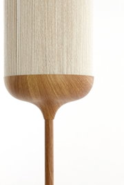 Nahaufnahme einer modernen Pendelleuchte mit beigefarbenem, geripptem Schirm und Holzoptik-Element, frontal von der Seite vor weißem Hintergrund.