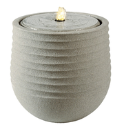 Grauer, runder Brunnen aus recyceltem Kunststoff mit gerippter Oberfläche und sprudelndem Wasser an der Spitze, seitliche Perspektive