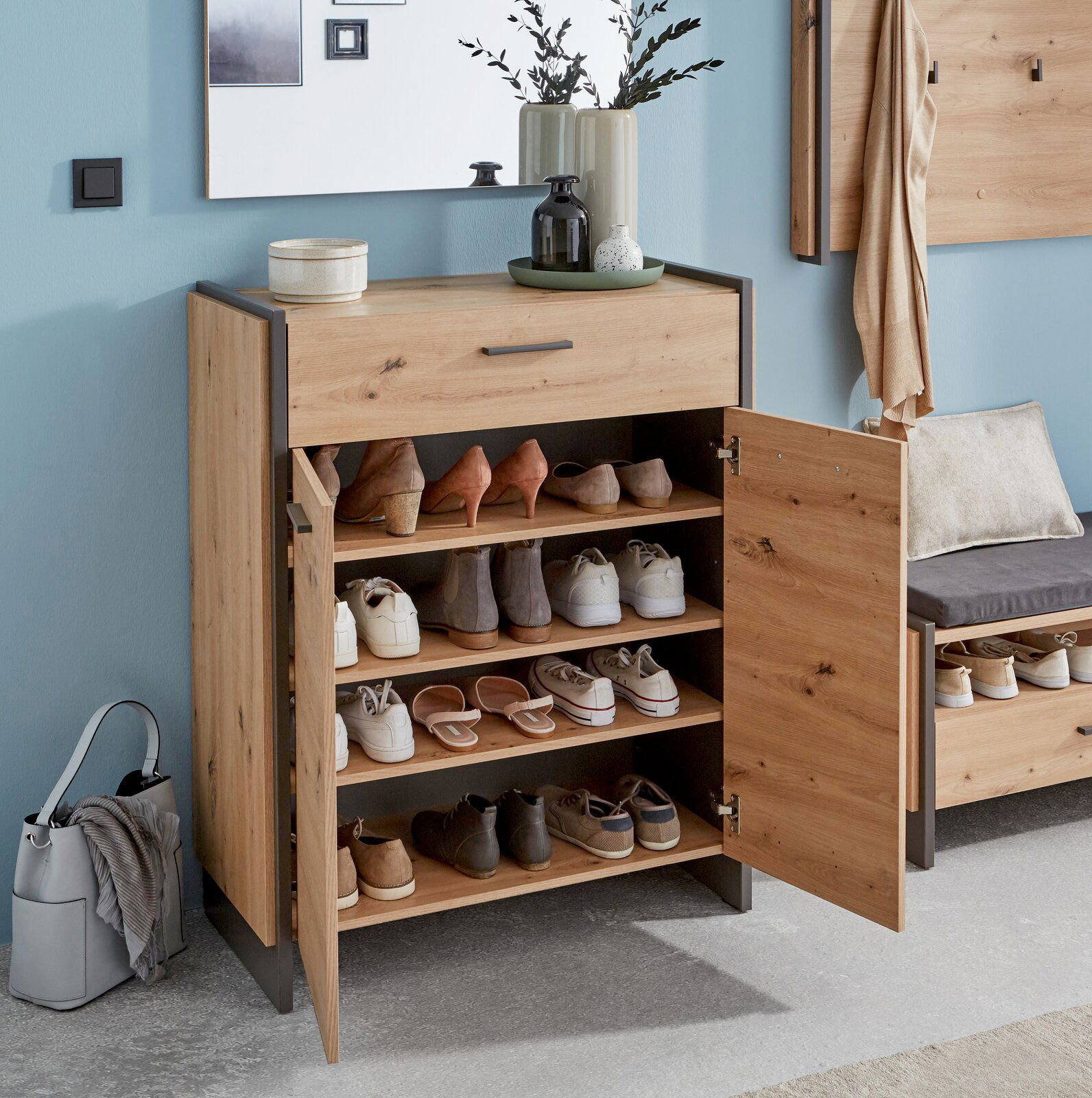 Moderner Schuhschrank aus Holz mit mehreren Fächern, gefüllt mit verschiedenen Schuhen, in einer stilvollen Wohnumgebung. Frontalansicht.