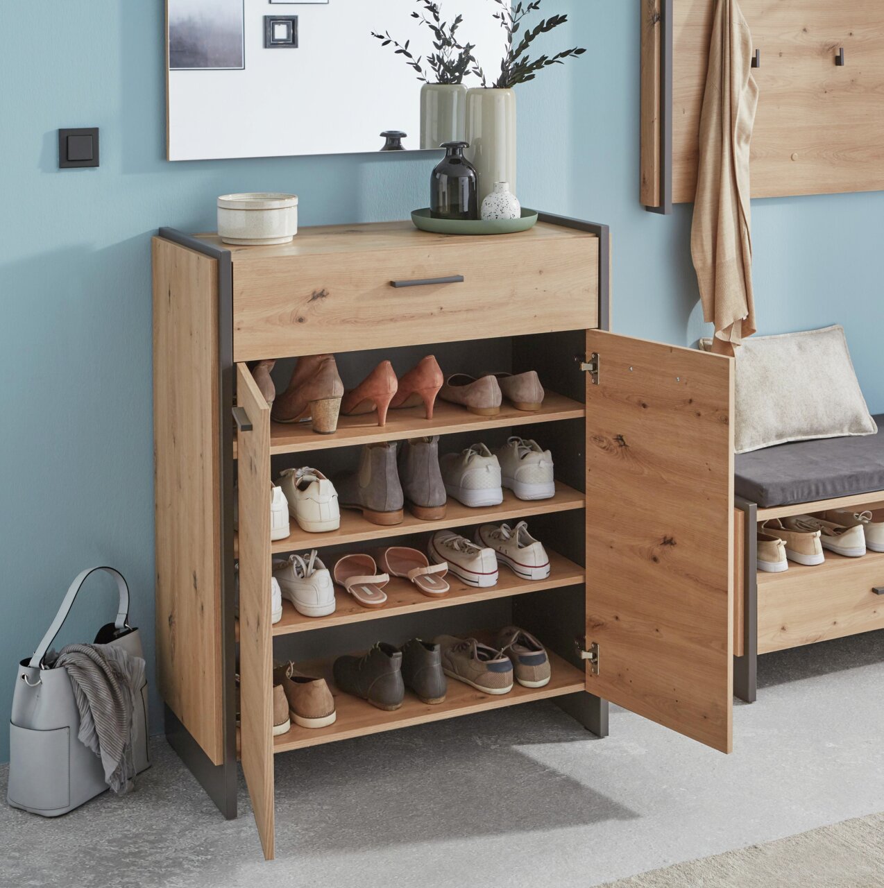 Moderner Schuhschrank aus Holz mit mehreren Fächern, gefüllt mit verschiedenen Schuhen, in einer stilvollen Wohnumgebung. Frontalansicht.