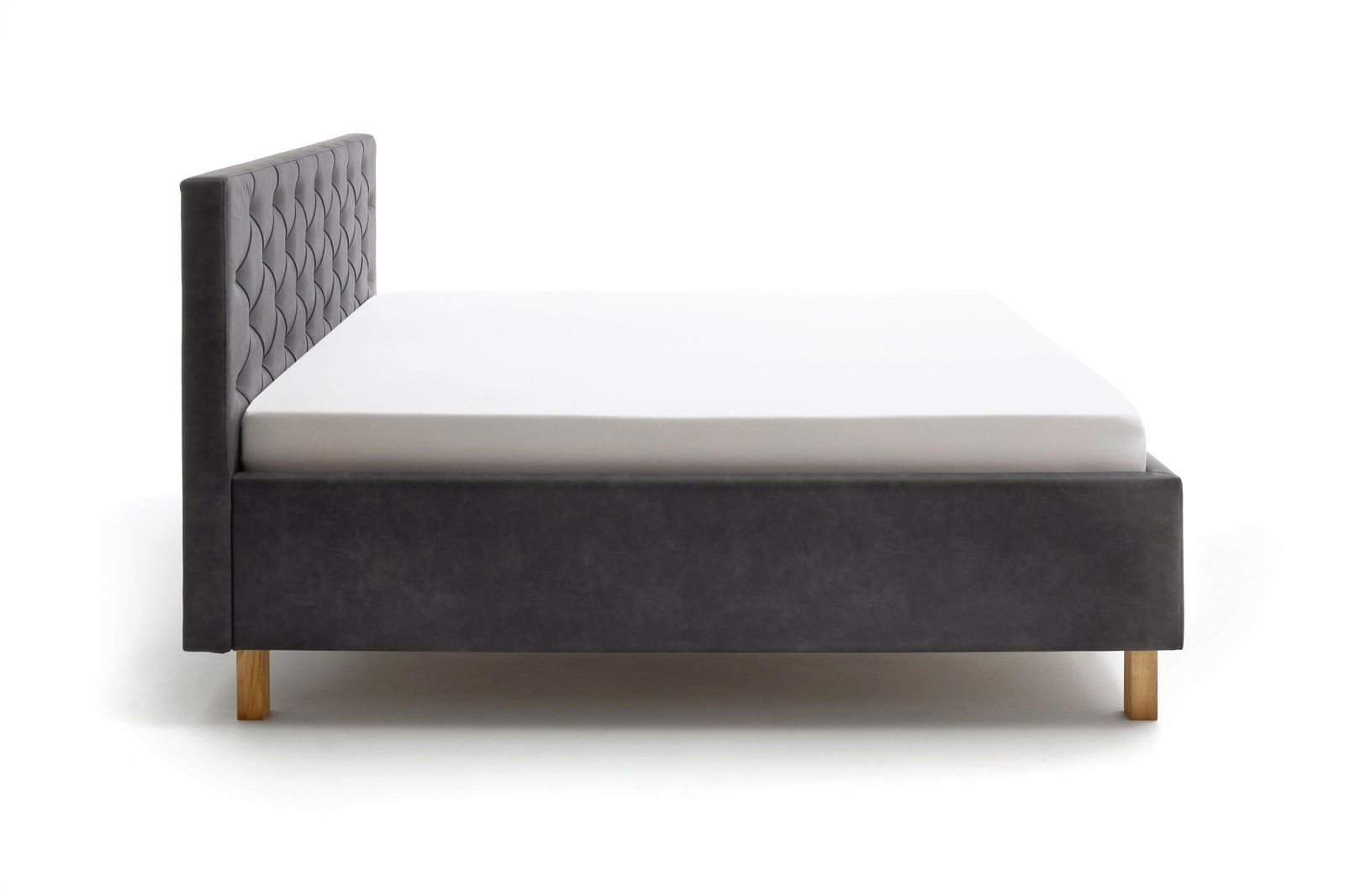 Seitliche Ansicht eines grauen Polsterbetts mit gestepptem Kopfteil und Holzfüßen.
