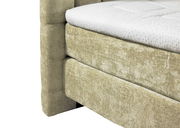 Nahaufnahme eines Boxspringbetts 180x200 mit beigem Stoffbezug und weißer Matratze, seitliche Perspektive