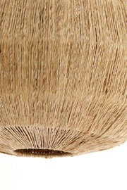 Close-up van een hanglamp van gevlochten natuurmateriaal, gezien van onderaf.