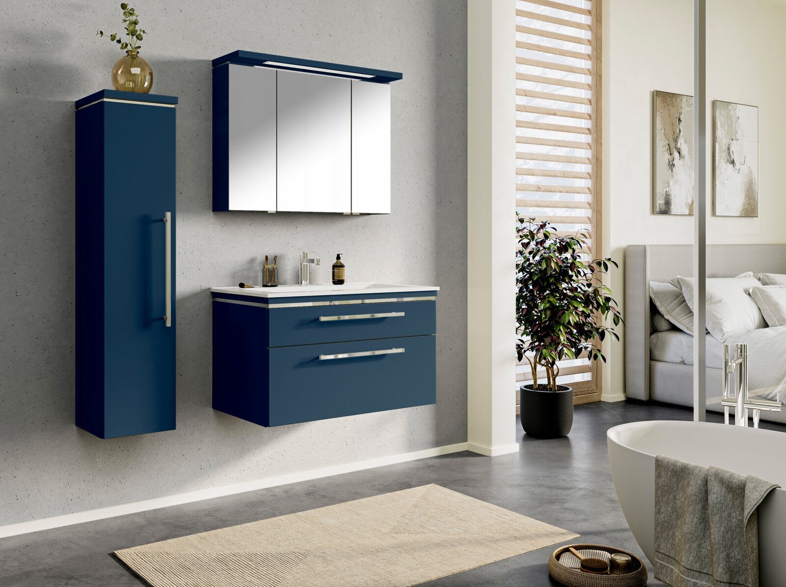 Modernes Badmöbel-Set in Dunkelblau mit wandhängendem Waschtischunterschrank, weißem Waschbecken, hohem Hochschrank und Spiegelschrank mit Beleuchtung; Ansicht schräg von vorne in einem hellen Badezimmer.