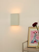 Moderne Wandleuchte in minimalistischem Design, seitliche Perspektive, mit sanftem Lichtschein nach oben und unten.
