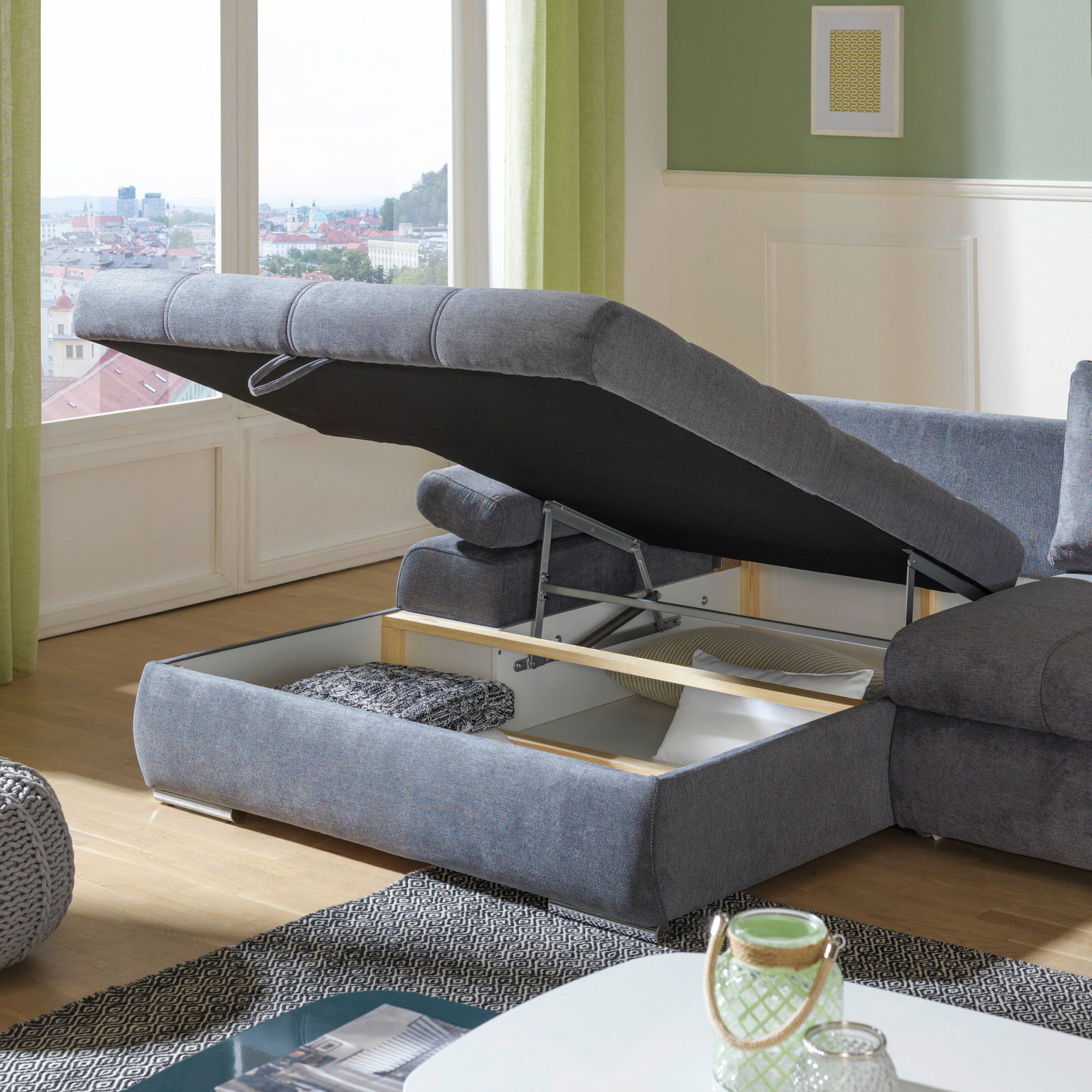 Graue Rundecke mit Stauraum, geöffnet, in einem modernen Wohnzimmer mit Blick auf die Stadt.