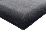 Ecke eines grauen Wollteppichs in Nahaufnahme, von oben betrachtet