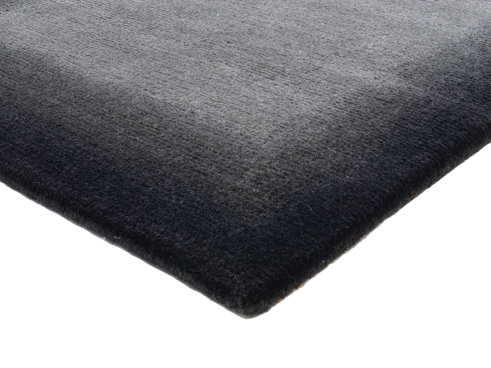 Ecke eines grauen Wollteppichs in Nahaufnahme, von oben betrachtet