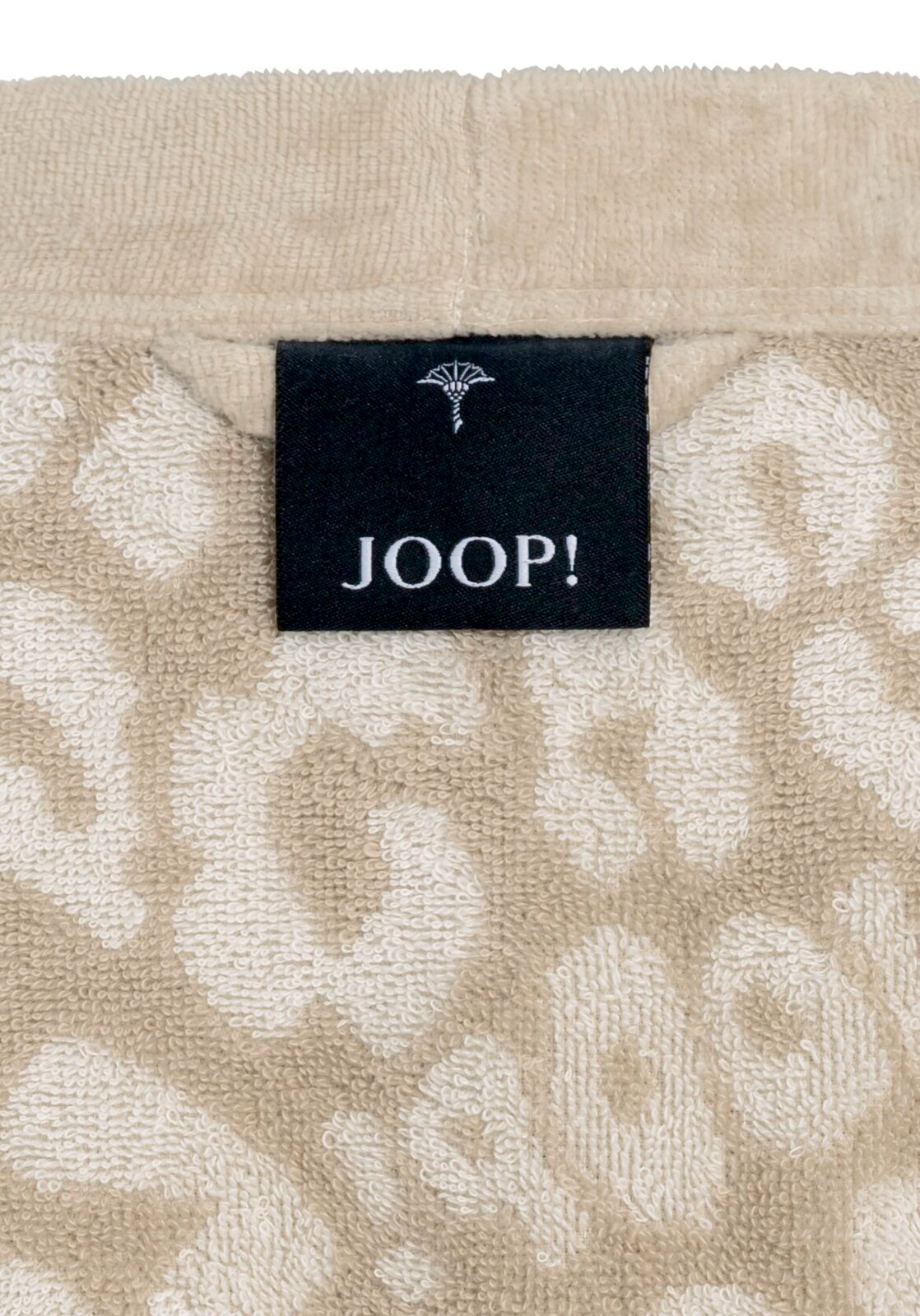 Close-up van een beige badjas met een zwart label van het merk JOOP!