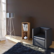 Modernes Wohnzimmer-Setting mit schwarzem Ledersessel, schlanker Stehlampe und kleinem Holzregal mit Büchern und Vase, fotografiert aus leicht erhöhter Frontansicht.