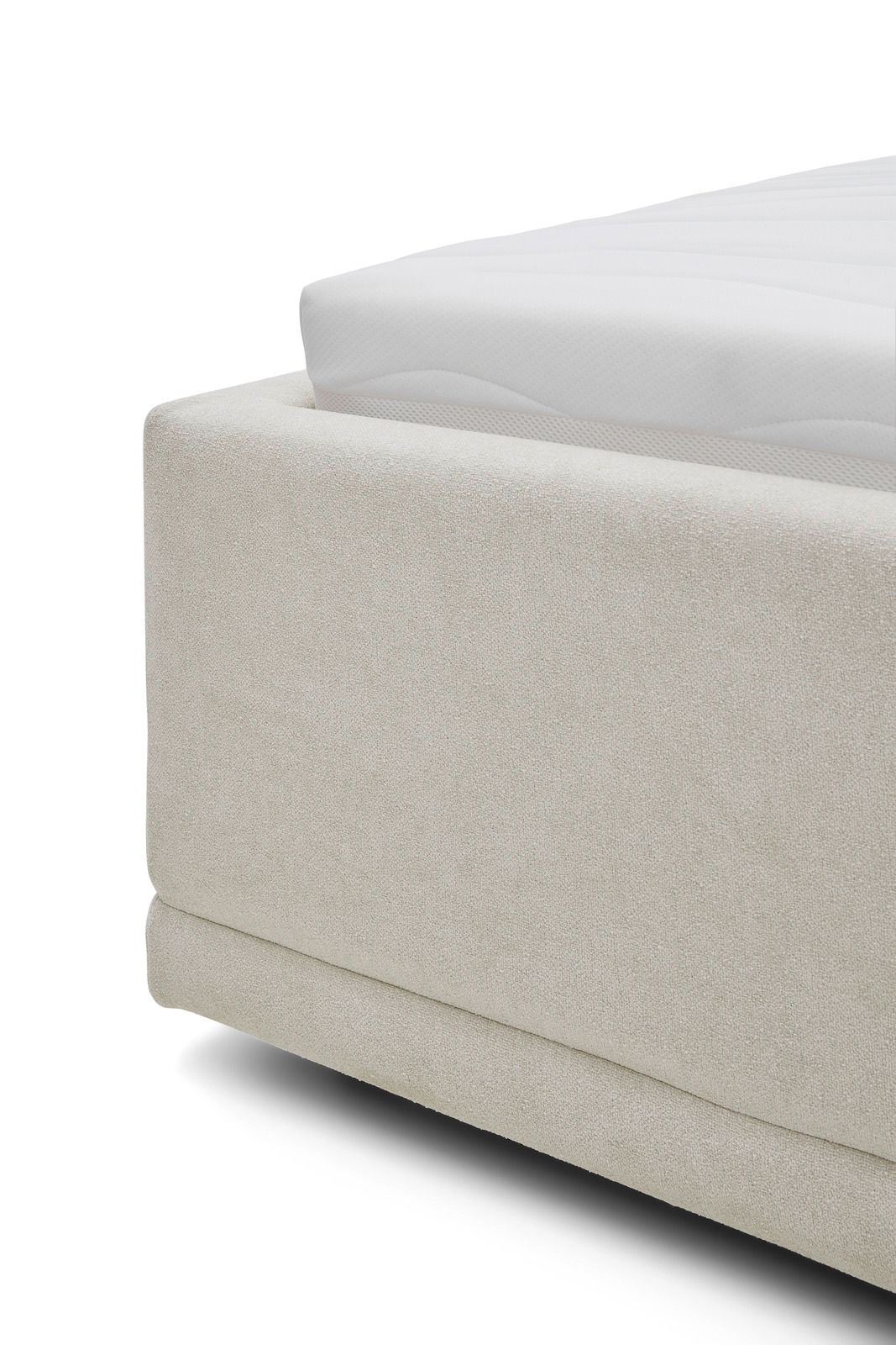 Nahaufnahme eines Polsterbettgestells in cremefarbener Textur, seitliche Perspektive