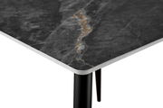 Nahaufnahme einer Tischkante mit dunkler, marmorierter Oberfläche und schwarzem Tischbein, perspektivisch von oben fotografiert.