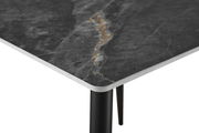 Nahaufnahme einer Tischkante mit dunkler, marmorierter Oberfläche und schwarzem Tischbein, perspektivisch von oben fotografiert.