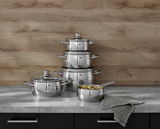 Topfset Quality One 5-tlg. aus Edelstahl, bestehend aus vier Töpfen und einer Stielkasserolle, auf einer Küchenarbeitsplatte vor einer Holzwand, seitliche Perspektive.