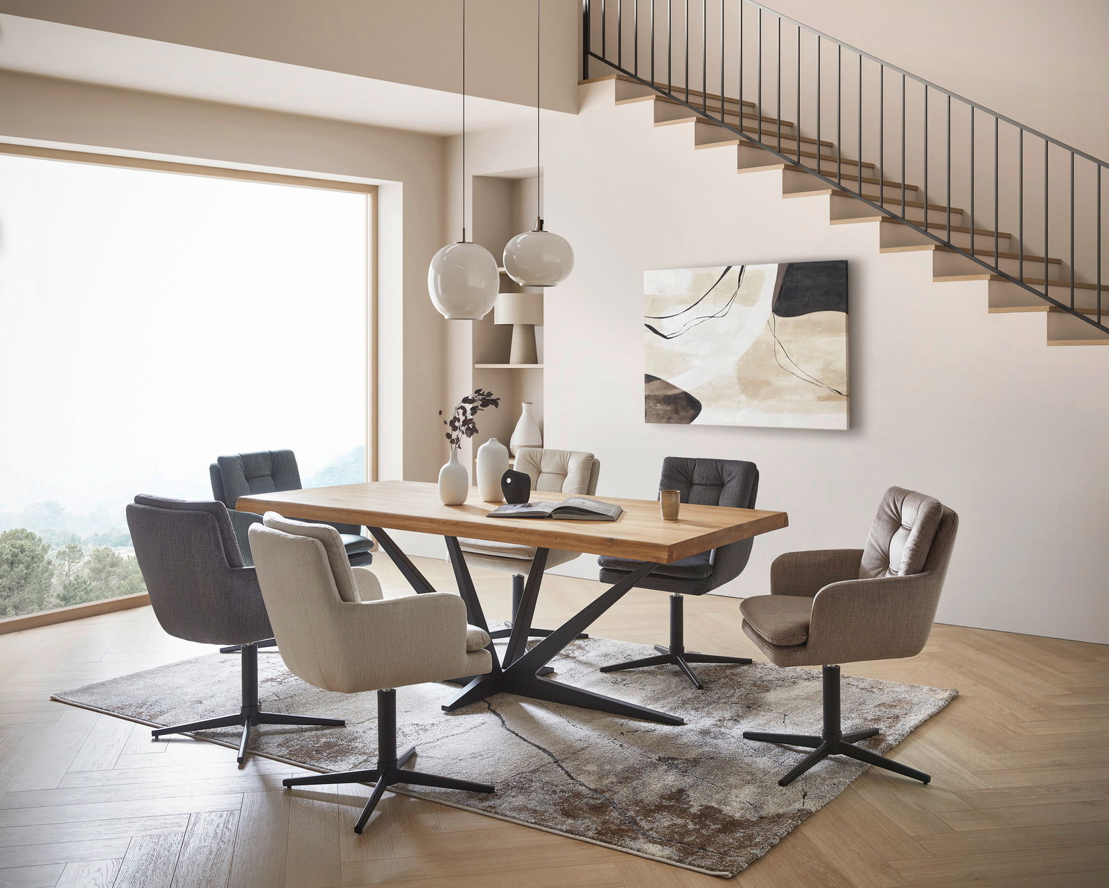 Novel Armlehnstuhl INGO Moderner Essbereich mit einem großen Holztisch und sechs gepolsterten Armlehnstühlen in verschiedenen Farben, seitliche Perspektive.